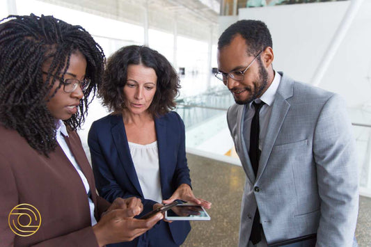 Three business professionals collaborating over a tablet in an office - Level 3. Mastering ACTIVE© Leadership
