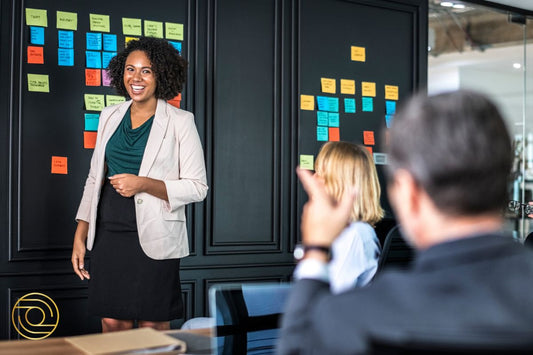Executive Impact and Influence: leader presents by sticky-note strategy wall; colleagues engage and ask questions in meeting.