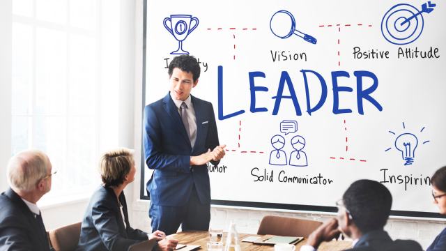 LEAD© Forum: Middle and senior managers in a boardroom presentation on leadership vision, attitude, and communication.