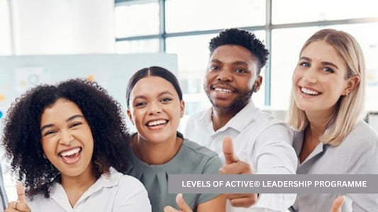 Four diverse professionals smiling and giving thumbs up during the Levels of ACTIVE Leadership Programme group training