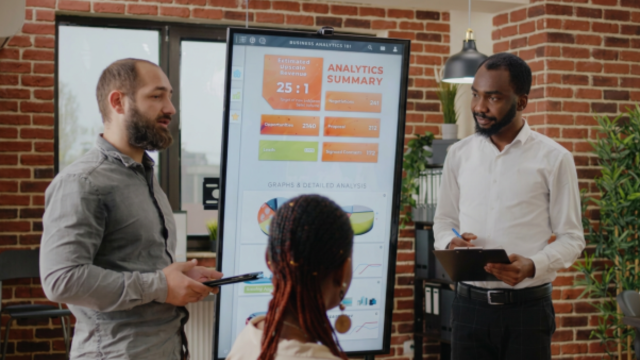 People standing around board looking at analytics