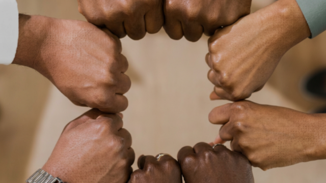 Hands in fists touching and forming a circle